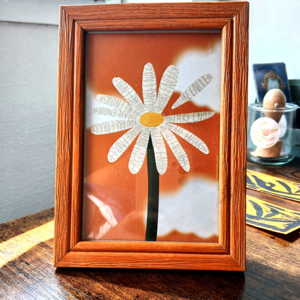 Carte format A6 "You are enough" encadrée dans un cadre orange, posée sur un bureau